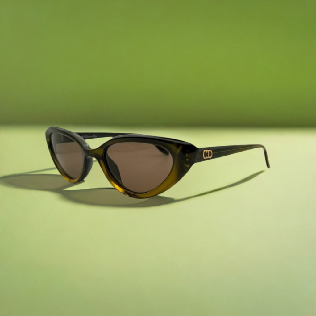 Green retro style Christian Dior sunglasses on a green background