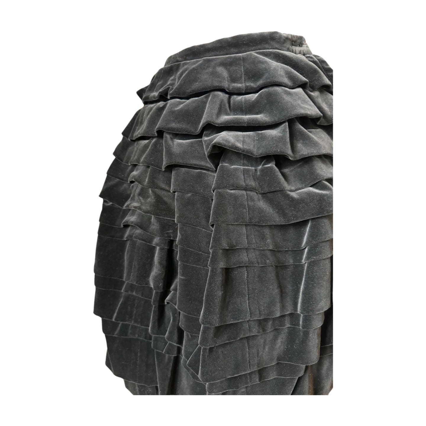 Close-up of a garment featuring multiple layers of dark gray, textured fabric arranged in a tiered, ruffled pattern. The voluminous and intricate design recalls the 90s Comme des Garçons aesthetic, showcasing unique layering techniques reminiscent of the Vintage 1990 Comme des Garçons Skirt.