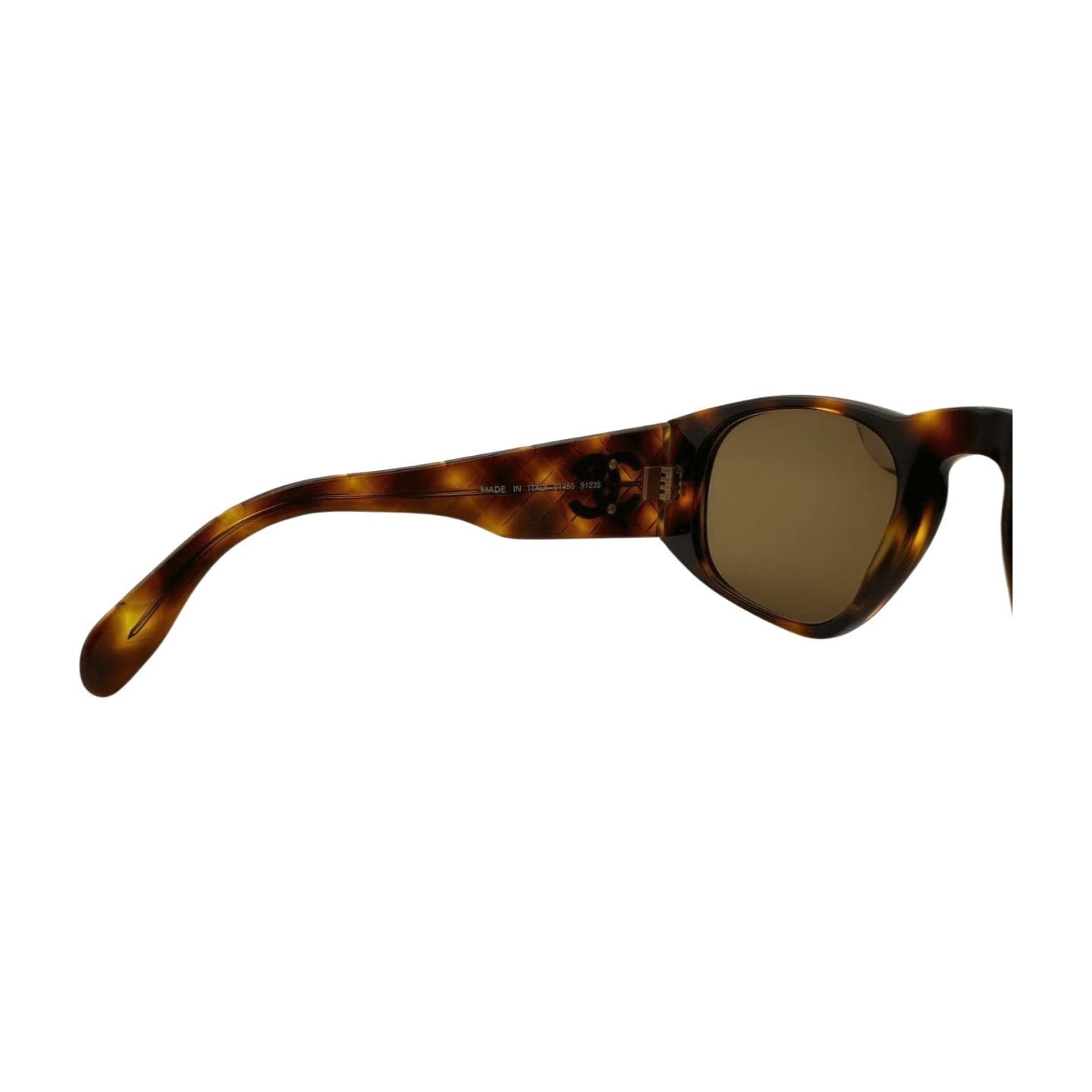 Side view of a pair of Vintage 90’s Chanel Sunglasses with brown tortoiseshell-patterned frames, dark lenses, and quilted arms by Chanel. The frame has a slight curve at the temple.