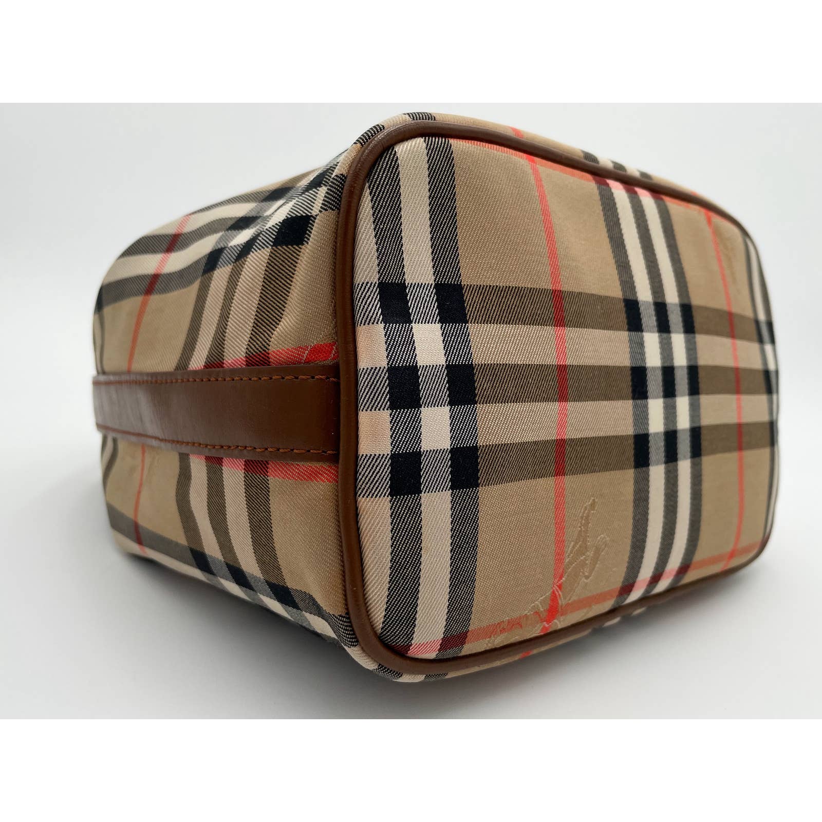 Rectangular toiletry bag with a distinctive plaid pattern of beige, black, white, and red. The Burberry Vintage House Check Bag features a zip top and leather handle on the side with reinforced corners. The canvas with leather trim fabric showcases a classic checkered design on a white background by Burberry.